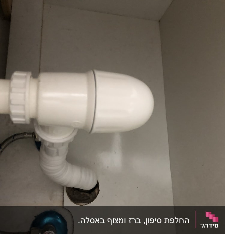 צינור פלסטיק לבן מתחת לכיור עם חיבורים